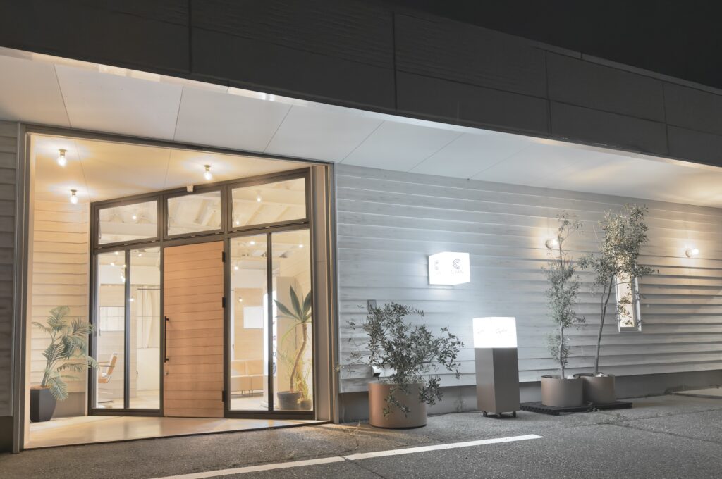 CyANヘアサロン外観。自然光が差し込む白い外壁とグリーンが印象的なエントランス。